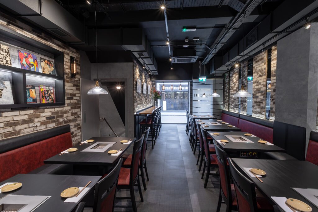 Modern Japanese BBQ restaurant interior with integrated grill tables, exposed ceiling, and industrial-style finishes – complete fit out by FITTRO for Hachi BBQ, Soho.